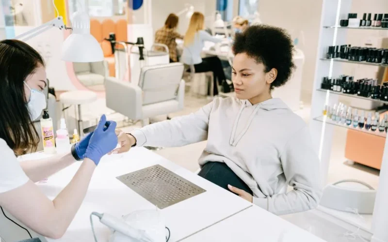 Pregnant woman enjoying a manicure at a salon. Relaxing self-care moment.
