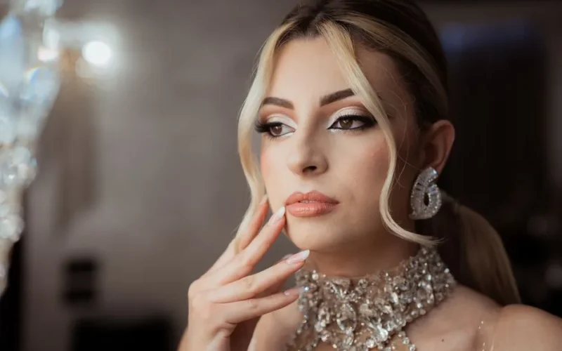 Sophisticated portrait of a woman in evening makeup and sparkling jewelry, exuding elegance and grace.