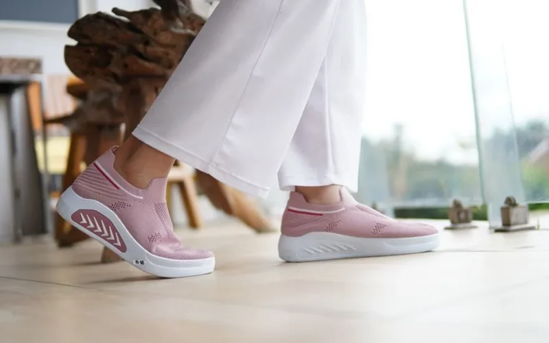 Fashionable pink sneakers paired with white pants, perfect for casual indoor settings.