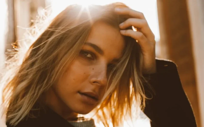 Warm portrait of a woman with sunlight shining through her hair, creating a soft, dreamy effect.