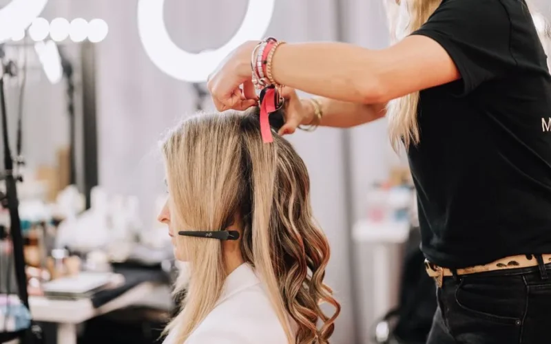 A stylist working on a blonde woman's hair during a studio session in Barcelona, Spain.