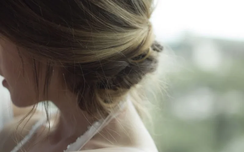 Close-up of elegant blonde updo hairstyle on a woman indoors.