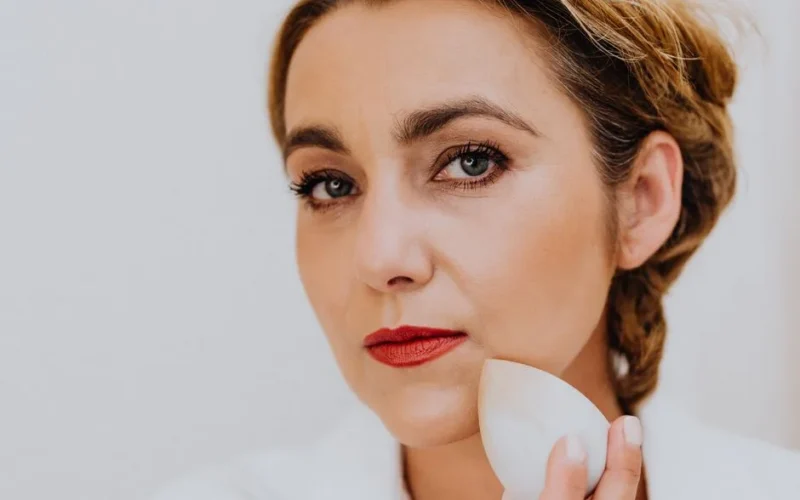 Close-up of a woman using a sponge for makeup application. Beauty and skincare concept.
