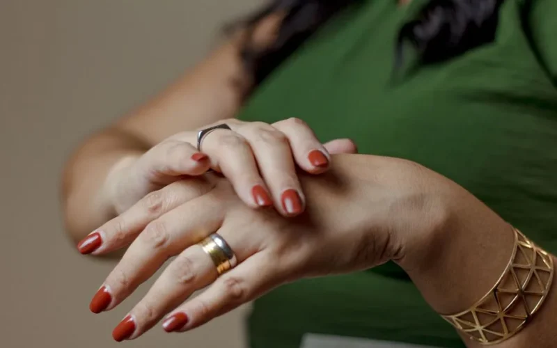 Close-up of elegant woman's hands with rings and bracelet, showcasing nail polish in Rio.