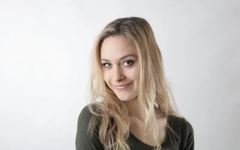 Portrait of a smiling woman with blonde hair on a white background.