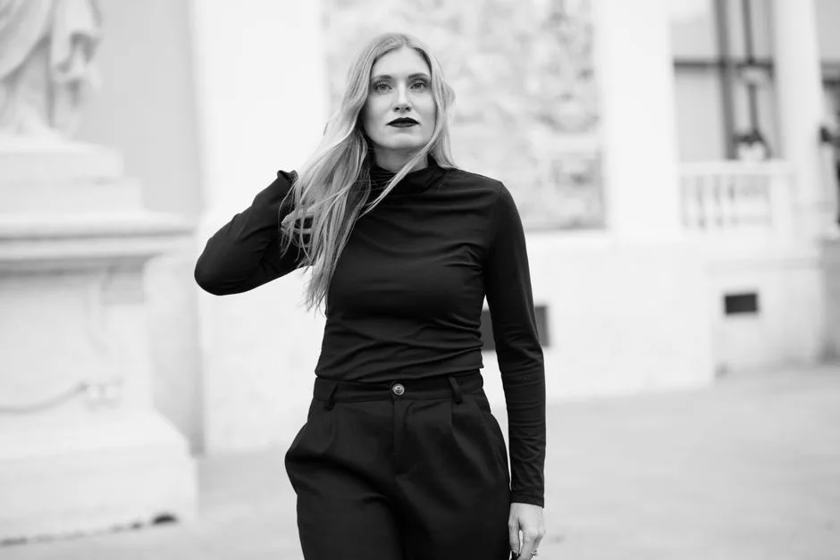Contemporary black and white portrait of a stylish woman in an urban setting.